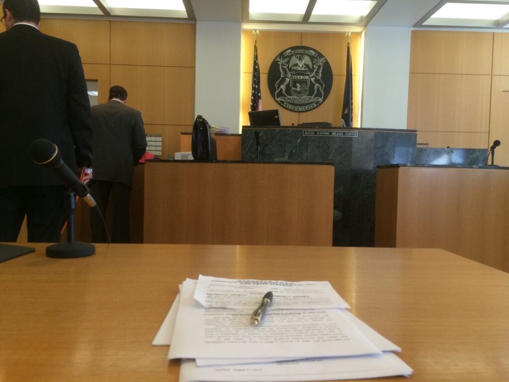 Courtroom with empty table and documents.
