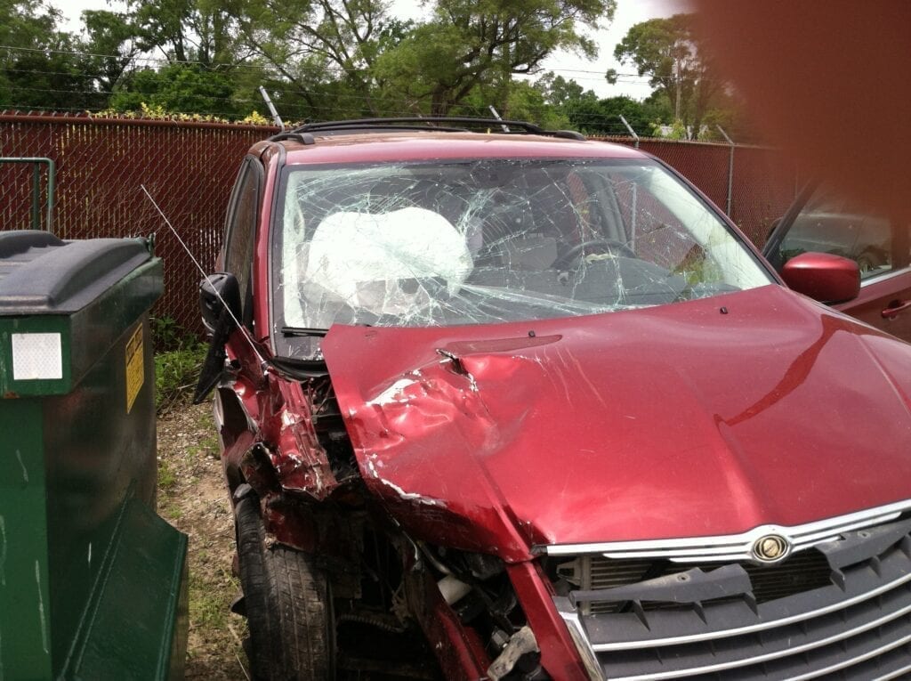 Red car with front-end collision damage.